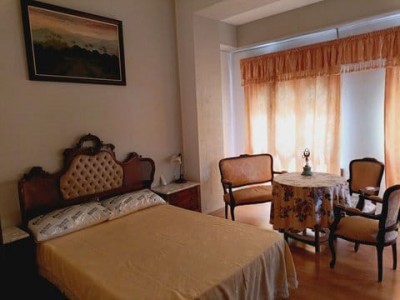 Спальня с кроватью и столом, оформленная в классическом стиле