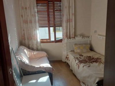 Уютная комната с кроватью и креслом у окна