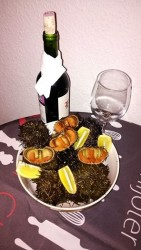 Бутылка вина, бокал и морские ежи с лимоном