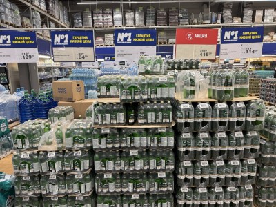 Полки с бутылками воды и акциями в магазине