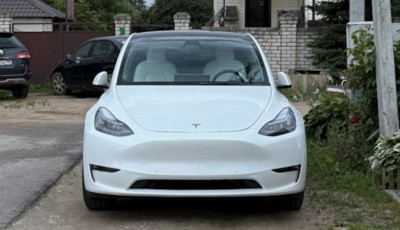 Белый электромобиль Tesla на парковке в жилом районе (в Испании)