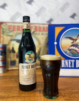 На фото бутылка фурнета "Fernet Branca" и стакан с напитком.