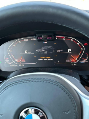 Приборная панель автомобиля BMW с информацией о техническом обслуживании.