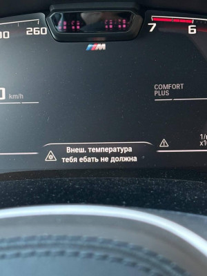 На фото приборная панель автомобиля с предупреждением о температуре.