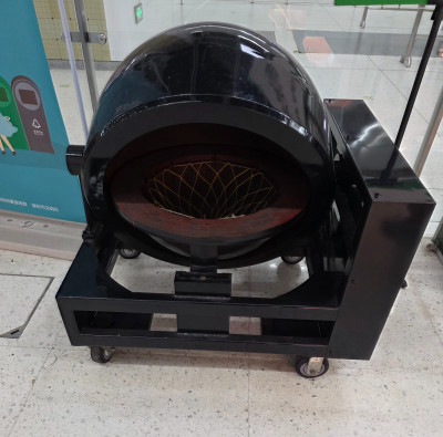 Чёрная машина для приготовления еды с круглой камерой.