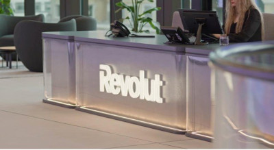Ресепшен компании Revolut с логотипом и сотрудником.