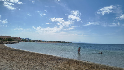 Пейзаж пляжа с людьми, купающимися в море, в Испании