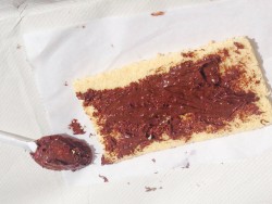 Бисквит с шоколадной пастой и ложкой рядом