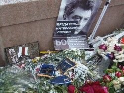 Цветы и плакаты у памятного места