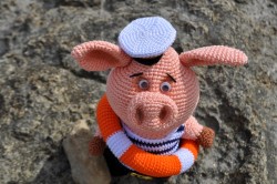 Вязаная игрушка свинки в морской форме с кругом спасателя