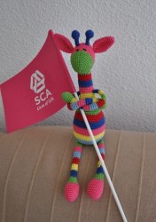 Вязаная игрушка жирафа с флажком в руках