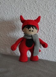 Вязаная игрушка в красном костюме с ушками и шарфом