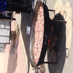 Большая сковорода с мясом на открытом огне
