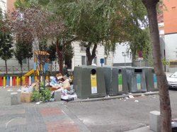 Мусорные контейнеры, заваленные отходами, рядом с деревьями