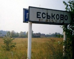 Знак населённого пункта Еськово на фоне поля