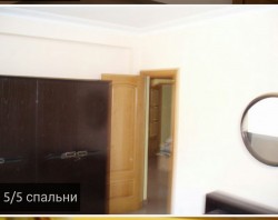 Спальня с темным шкафом и круглым зеркалом
