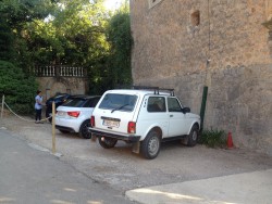 Парковка с белым внедорожником и двумя другими автомобилями